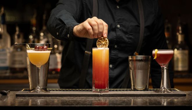 bartender garnishing a cocktail at the bar